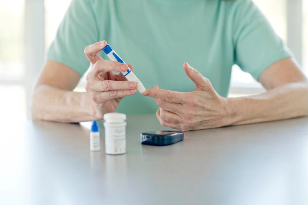 Oseba izvaja hitri test za merjenje glukoze.