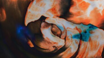 Abstraktni valovi različnih odtenkov oranžno-rdeče.