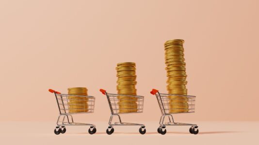 Trije nakupovalni vozički, vsak ima več cekinov v njem, kar nakazuje na inflacijo.